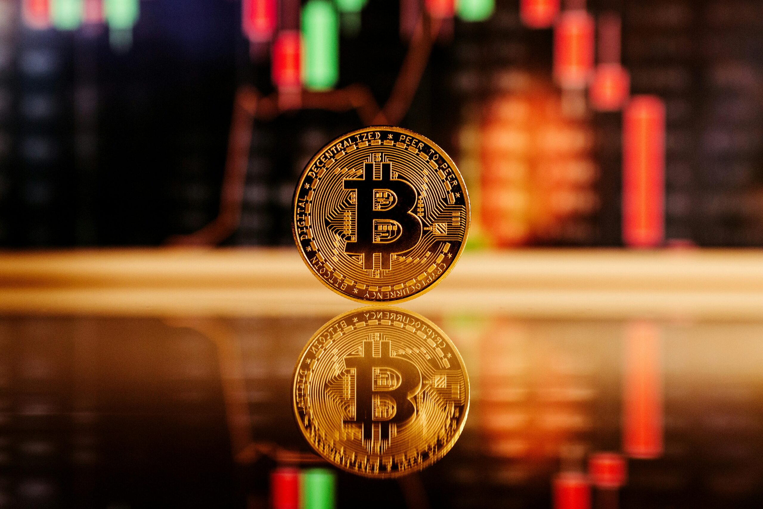 What is Trading ? Complete Guide for Beginners 2026 Close-up of a Bitcoin coin with a stock market chart background, symbolizing cryptocurrency trading.